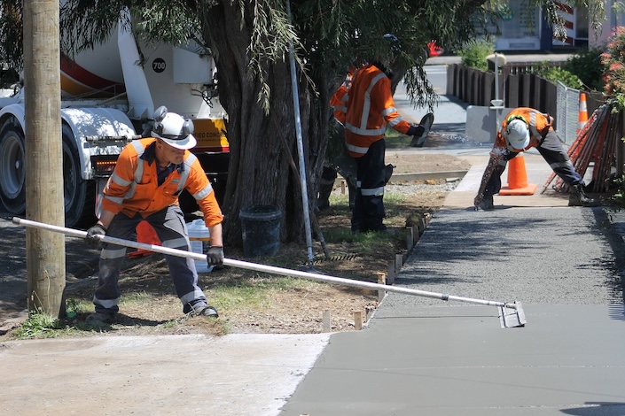 Worker smoothing freshly poured concrete