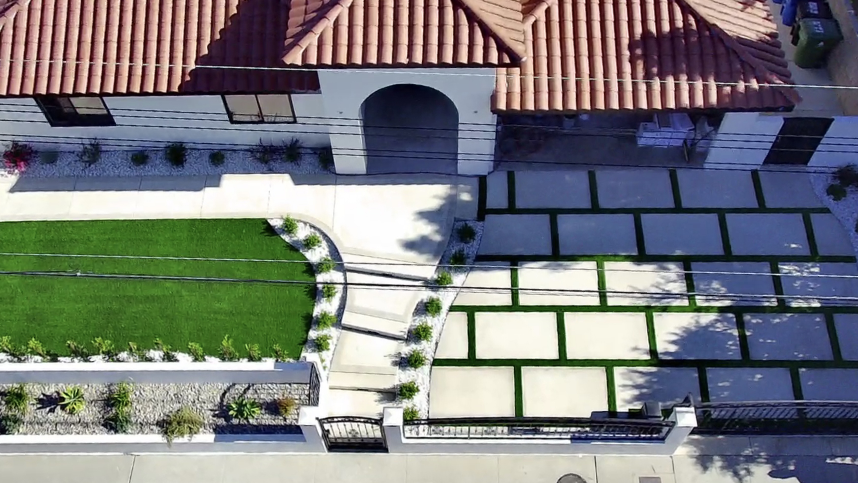 Modern patio with large geometric pavers and turf strips